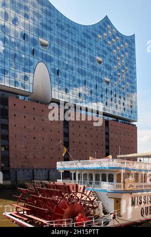 Le bateau à aubes Mississippi Queen se trouve sur le quai en face de l'Elbphilharmonie dans la ville de HafenCity, en Allemagne, par une journée ensoleillée. Banque D'Images