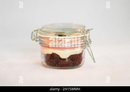 Pot isolé transparent fermé avec dessert délicieux et sucré à l'intérieur, divisé en couches sur fond blanc Banque D'Images