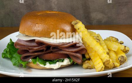 jambon de miel sur le dessus d'un petit pain avec du fromage provolone, et servi avec un côté de frites Banque D'Images