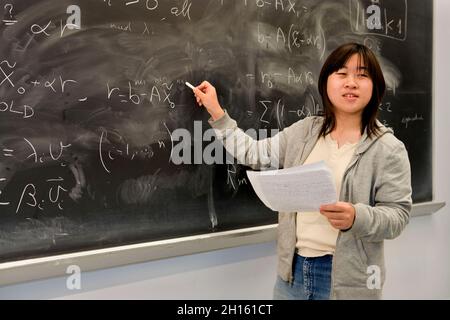 Chinese student at blackboard in a math class MR - Model Released Stock Photo