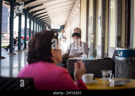 LJUBLJANA, SLOVÉNIE - 16 JUIN 2021 : flou sélectif sur l'homme, homme âgé, buvant du café en vérifiant son smartphone sur la terrasse d'une ca Banque D'Images