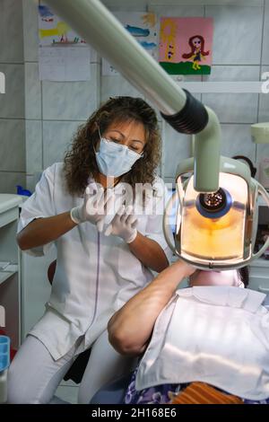 Dentiste sud-américain vérifiant les dents d'une femme d'âge moyen de race blanche Banque D'Images