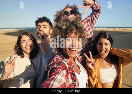 Groupe d'amis heureux multiraciaux prenant le selfie et s'amusant ensemble. Banque D'Images