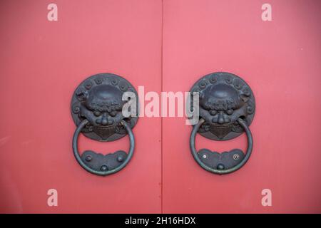 Poignée de porte à tête de lion avec porte en bois de style chinois rouge Banque D'Images