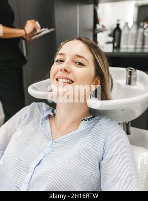 Grand corps heureux jeune asiatique homme porter une tenue légère et décontractée et chapeau orange debout avec les bras étirés sur les tiptoes et regarder vers le bas avec le sourire Banque D'Images