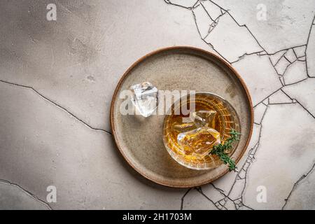 Verre de whisky avec glace sur fond de pierre grise.Vue de dessus avec espace de copie Banque D'Images