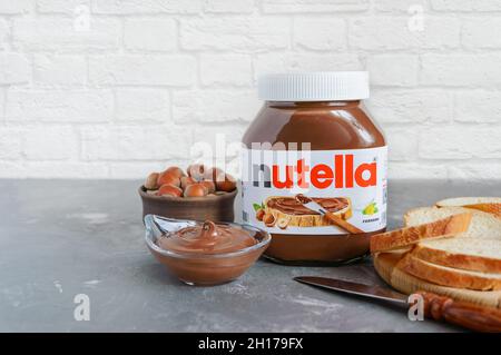 KREMENCHUG, UKRAINE - 9 OCTOBRE 2021 : pot en verre Nutella dans la cuisine avec du pain frais pour le petit déjeuner.Pâte de cacao aux noisettes sucrée - large Banque D'Images