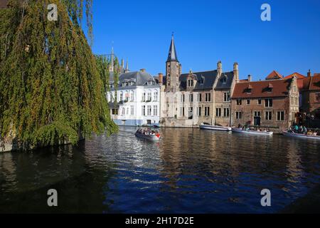 Brugge (Rozenhoedkaai), Belgique - octobre 9.2021: Vue sur le canal d'eau sur la jetée avec des bateaux touristiques, des bâtiments médiévaux, un arbre vert contre Banque D'Images