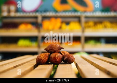 Vue rapprochée de l'avant du salak frais mûr juteux couché sur une palette en bois à la section fruits et légumes de l'épicerie. Banque D'Images