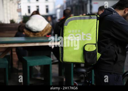 Gand, Belgique - octobre 9.2021: Gros plan de uber Eats personne de service de livraison de la nourriture sur le vélo avec le sac vert à dos dans le centre-ville (se concentrer sur l'avant de Banque D'Images