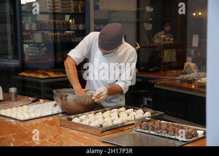 Gand, Belgique - octobre 9.2021: Vue à travers la fenêtre d'affichage dans la boulangerie belge avec boulanger mâle préparant de la pâte fraîche Banque D'Images