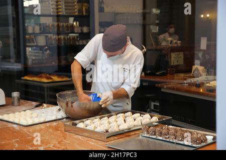 Gand, Belgique - octobre 9.2021: Vue à travers la fenêtre d'affichage dans la boulangerie belge avec boulanger mâle préparant de la pâte fraîche Banque D'Images