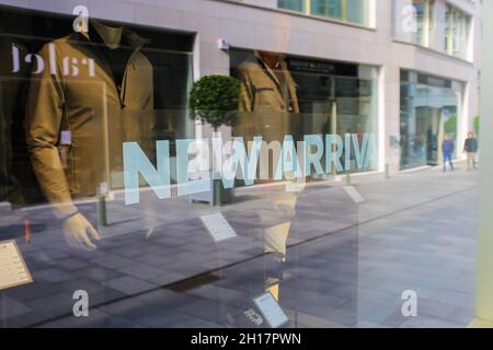 Gand, Belgique - octobre 9.2021: Gros plan du texte nouvelles arrivées sur la fenêtre d'affichage de magasin de mode (Focus sur la lettre N) Banque D'Images