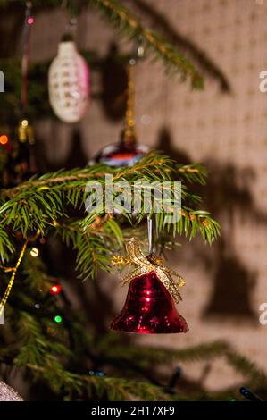 Nouvel an ou Noël en direct décoré avec élégance épinette gros plan - cloche rouge sur le fond de branches vertes.Jouets du nouvel an, bonheur, joie, Banque D'Images