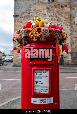 Décoration de récolte en bonneterie sur la boîte postale Royal Mail, bureau de poste du village d'Ormiston, East Lothian, Écosse, Royaume-Uni Banque D'Images