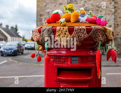Décoration de récolte en bonneterie sur la boîte postale Royal Mail, bureau de poste du village d'Ormiston, East Lothian, Écosse, Royaume-Uni Banque D'Images