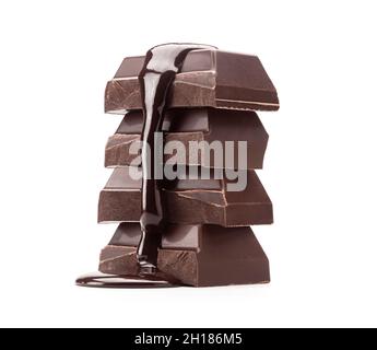 Pile de morceaux de barres de cuisson au chocolat noir avec sauce au chocolat fondu versé sur un fond isolé sur fond blanc Banque D'Images