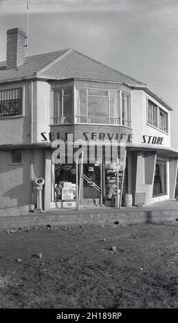 Années 1950, historique, vue extérieure d'une nouvelle maison d'alimentation de village semi-rurale, Witney, Oxford, Angleterre, Royaume-Uni,avec hébergement ci-dessus.C'était le début de l'ère du nouveau magasin « Service de beauté », comme l'indique le panneau au-dessus de l'entrée, où le client a fait le tour de la cueillette de ses propres produits d'épicerie. Banque D'Images