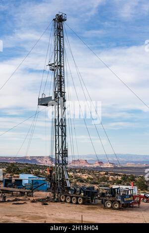 Une unité de traction ou un engin de chantier sur un puits de pétrole dans l'Utah.Derrière se trouvent les falaises Monitor & Merrimac Buttes & Book. Banque D'Images