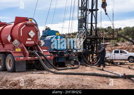 Un engin de reprise avec un camion-citerne et un camion-pompe acidilisant un puits de pétrole pour restaurer la production.Utah. Banque D'Images