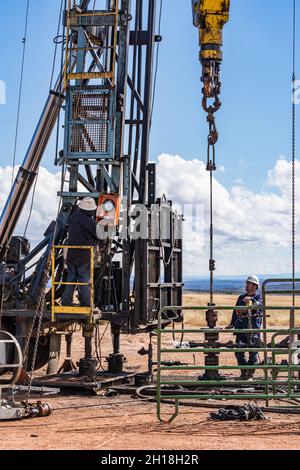 L'opérateur sur un engin de maintenance de puits exécutant les commandes de l'engin sur un puits de pétrole. Banque D'Images