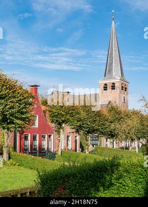 L'église Maurice et les jardins au bord de l'eau sur le canal Eegracht dans la ville d'IJlst, Frise, pays-Bas Banque D'Images