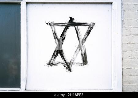 Graffiti Star of David hexagram peint en noir sur panneau blanc Banque D'Images