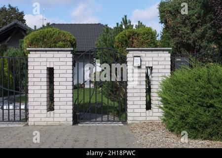 Clôture moderne en brique et guichet en métal.Interphone à l'entrée de la propriété. Banque D'Images