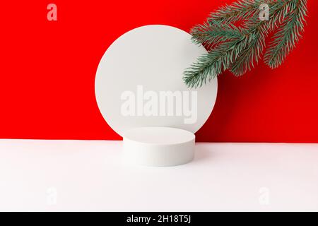 Podium avec décorations de noël sur fond créatif rouge et blanc.Modèle de maquette pour l'affichage du produit. Banque D'Images