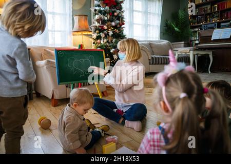 Enfant avec masque et enfants jouant ensemble. Éducation, concept de coronavirus Banque D'Images