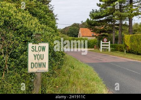 Panneau de vitesse routière « Slow You Down » en approche de Weybourne sur la côte nord de Norfolk, East Anglia, Angleterre Banque D'Images