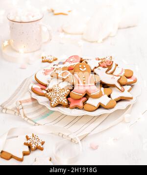 Joyeux pain d'épice biscuits de Noël sur un plateau avec rubans et lumières et chocolat chaud pour une scène de noël lumineuse. Banque D'Images