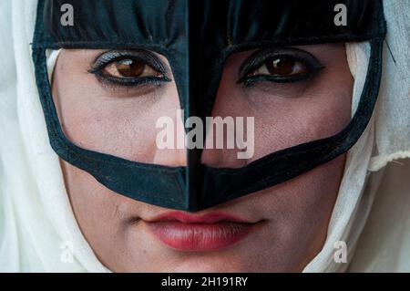 Portrait rapproché d'une femme bédouine portant un masque traditionnel.Wahiba Sands, Oman. Banque D'Images