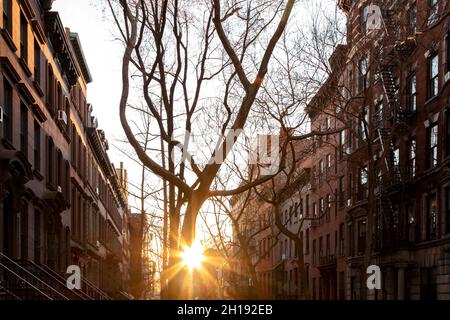 Bloc de bâtiments historiques en grès brun sur Perry Street dans le quartier West Village de New York avec lumière du soleil brillant en arrière-plan Banque D'Images