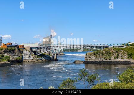 Pont Reversing Falls à saint John, Nouveau-Brunswick, Canada vu de l'autre côté de la rivière.Usine de pâte derrière le pont.Ciel bleu et rivière bleue par beau temps. Banque D'Images