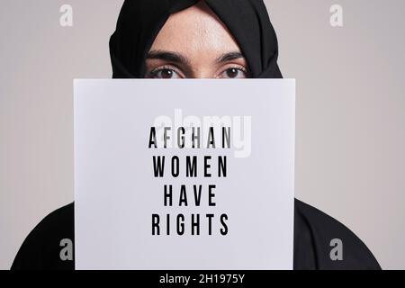 Femme musulmane tenant un papier avec du texte - les femmes afghanes ont des droits.Femme musulmane en vêtements hijab traditionnels.Violence domestique, discrimination Banque D'Images