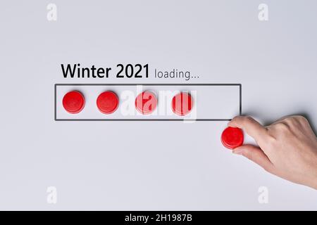 Chargement de l'hiver 2021 illustré avec des boutons rouges sur fond blanc.Symbole hiver 2021 à venir Banque D'Images