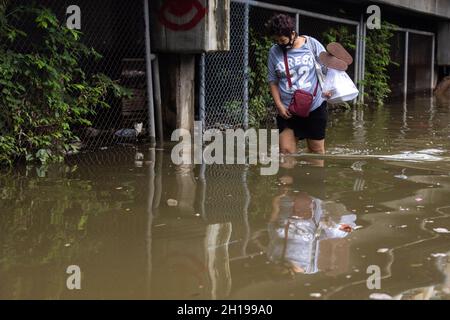 Bangkok, Thaïlande.17 octobre 2021.Une femme est vue marcher dans les eaux de crue après de fortes inondations.Santichon communauté Songkroh, une petite communauté le long du canal de Bangkok Noi est maintenant confrontée à des inondations quotidiennes influencées par les fuites de murs d'eau et de fortes précipitations de la tempête tropicale Kompasu.Crédit : SOPA Images Limited/Alamy Live News Banque D'Images
