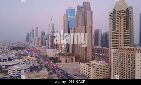 Vue sur les gratte-ciels modernes et les autoroutes animées le soir dans le centre-ville de luxe de Dubaï.Vue aérienne supérieure depuis le toit de la tour.Circulation aux intersections. Banque D'Images