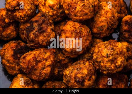 Un gros plan du détail des boulettes de viande fraîchement frites sur fond noir ; concept de cuisine Banque D'Images