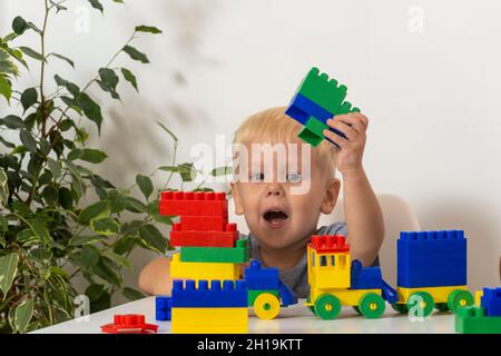 Les enfants jouent avec des blocs de construction éducatifs colorés.Petit garçon avec des jouets créatifs. Jeux pour les jeunes enfants.Enfant sur fond blanc Banque D'Images