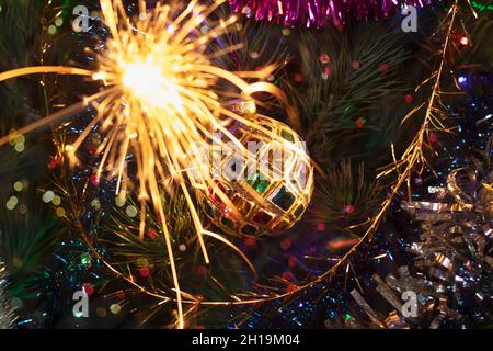 Carte de Noël avec une boule de vitraux multicolores sur l'arbre.Arbre de Noël avec guirlande lumineuse, sparkles, guirlandes lumineuses et sparkers pour CH Banque D'Images