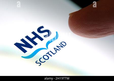 L'écran de connexion de l'application NHS Scotland apparaît sur le smartphone et le doigt le touche.Mise au point sélective.Concept.Stafford, Royaume-Uni, 17 octobre 2021. Banque D'Images