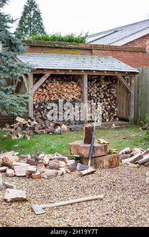 Pile de bois de chauffage haché à l'extérieur d'un magasin de bois dans un jardin du Royaume-Uni.Décrit le concept d'énergie renouvelable, de biomasse et de biocarburant Banque D'Images