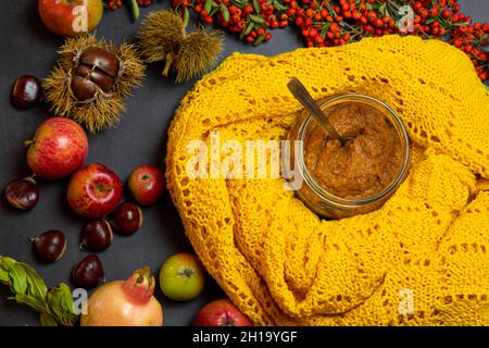 soupe de potiron sur fond noir, décorée de châtaignes jaunes, de pommes, de grenade, de baies sauvages orange Banque D'Images