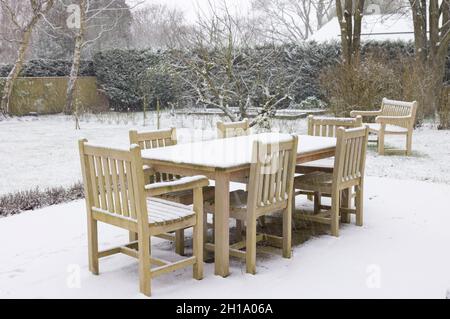 Mobilier de jardin patio, table et chaises en bois recouvertes de neige en hiver, Royaume-Uni Banque D'Images