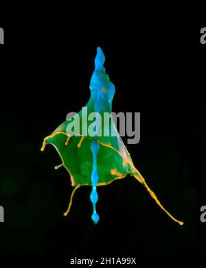 Les gouttes d'eau bleues et vertes tombent d'en haut et entrent en collision avec un jet jaune sous pression - Liquid Drop Art Banque D'Images