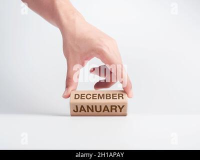 Passage au premier mois de l'année.La main est de retourner des blocs de cube en bois pour changer de mots, des mois de décembre à janvier sur le bureau sur whit Banque D'Images