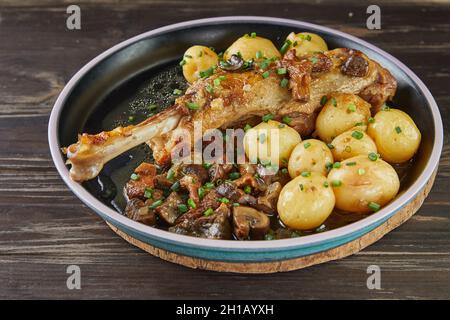 Queues d'oie avec portobello et champignons de la forêt cuits avec de nouvelles pommes de terre et armagnac.Cuisine gastronomique française Banque D'Images