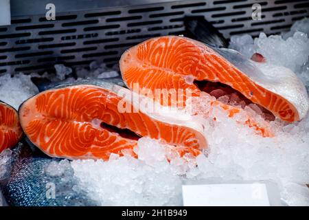 Steaks de saumon frais exposés sur la glace dans un marché au poisson Banque D'Images